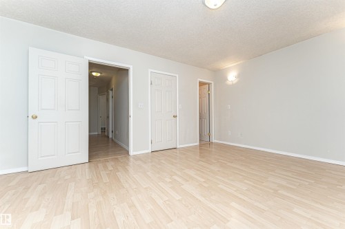 Light wood-finish flooring, neutral wall tones, and overhead lighting - 12241 93 Street Nw, Edmonton, AB - Indoor Photo Showing Other Room
