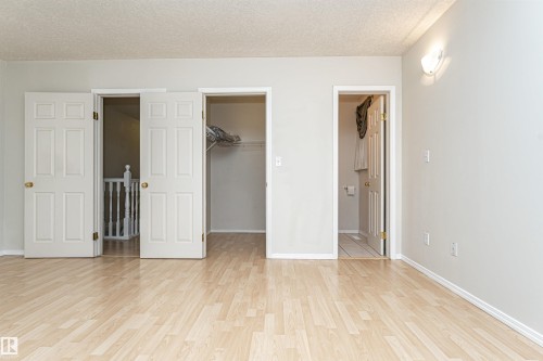 Wood-finish flooring throughout, with white trim and light gray walls - 12241 93 Street Nw, Edmonton, AB - Indoor Photo Showing Other Room