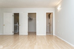 Wood-finish flooring throughout, with white trim and light gray walls - 
