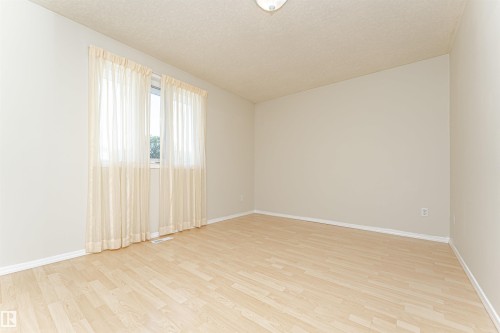 Light-toned wood-finish flooring complements the neutral wall color - 12241 93 Street Nw, Edmonton, AB - Indoor Photo Showing Other Room
