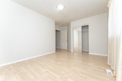 Light-toned wood-finish flooring, white walls, and a ceiling-mounted light fixture - 