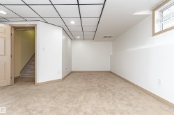 Finished lower level space featuring recessed lighting, a drop ceiling, and a light beige carpet - 