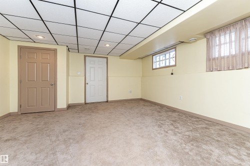 Recessed ceiling lighting, drop ceiling, two paneled doors, and a glass block window - 12241 93 Street Nw, Edmonton, AB - Indoor Photo Showing Other Room