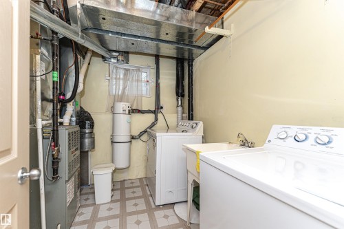 Utility space featuring a laundry sink, washer and dryer, and patterned floor tile - 12241 93 Street Nw, Edmonton, AB - Indoor Photo Showing Laundry Room