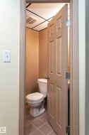 Compact lavatory with square floor tiles and a paneled door - 