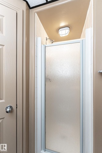 Shower enclosure with textured glass paneling and a chrome shower head - 12241 93 Street Nw, Edmonton, AB - Indoor Photo Showing Bathroom