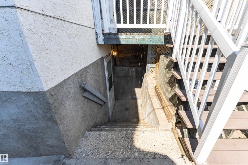 Exterior with textured stucco siding, concrete stairs, and a white deck railing - 12241 93 Street Nw, Edmonton, AB - Outdoor