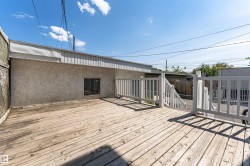 Outdoor wood deck featuring white painted railings and a staircase - 