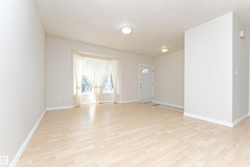 Light wood-finish flooring with white baseboards throughout - 12241 93 Street Nw, Edmonton, AB - Indoor Photo Showing Other Room