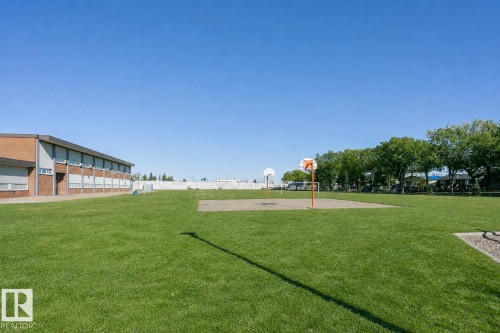 Expansive green space featuring a paved court with two basketball hoops - 12241 93 Street Nw, Edmonton, AB - Outdoor