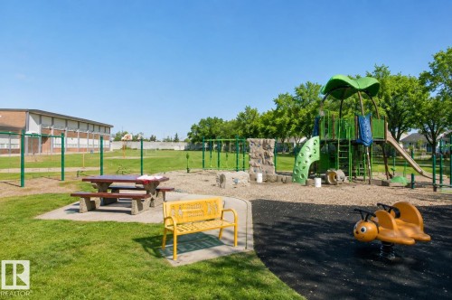 Outdoor recreational area featuring a playground structure with slide, rock climbing wall, and spring rider - 12241 93 Street Nw, Edmonton, AB - Outdoor