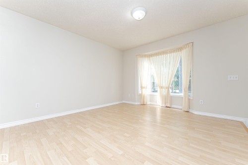 Wood-finish flooring, bay window, light wall tones, and recessed ceiling light - 12241 93 Street Nw, Edmonton, AB - Indoor Photo Showing Other Room