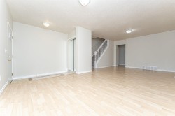 Wood-finish flooring, staircase with white risers, flush-mount lighting, and mirrored closet doors - 