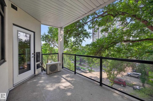 Outdoor balcony featuring a concrete floor, glass and metal railing, and a white paneled ceiling - #401 10178 117 St Nw, Edmonton, AB - Outdoor With Exterior