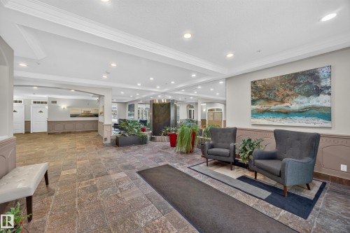 Spacious common area featuring stone tile flooring, recessed lighting, and crown molding - #401 10178 117 St Nw, Edmonton, AB - Indoor Photo Showing Other Room