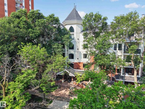 Multi-story building featuring a prominent turret, balconies, red brick accents, and a covered entrance - #401 10178 117 St Nw, Edmonton, AB - Outdoor