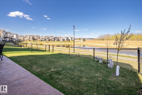 Expansive backyard with a stamped concrete patio and chain-link fencing - 7135 Edgemont Way Nw, Edmonton, AB 