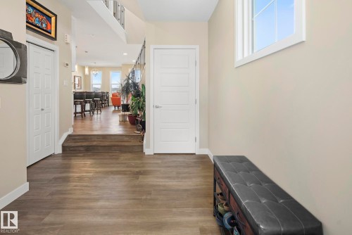 Wood-finish flooring, white trim, and a prominent window - 7135 Edgemont Way Nw, Edmonton, AB 
