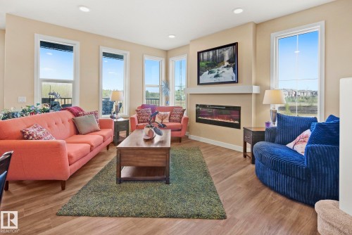 Recessed lighting, wood-finish flooring, multiple windows, built-in electric fireplace, and a mantel shelf - 7135 Edgemont Way Nw, Edmonton, AB 