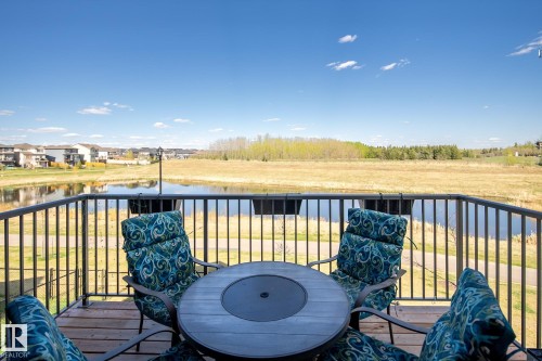 Outdoor deck with wood-finish flooring and a black metal railing - 7135 Edgemont Way Nw, Edmonton, AB 