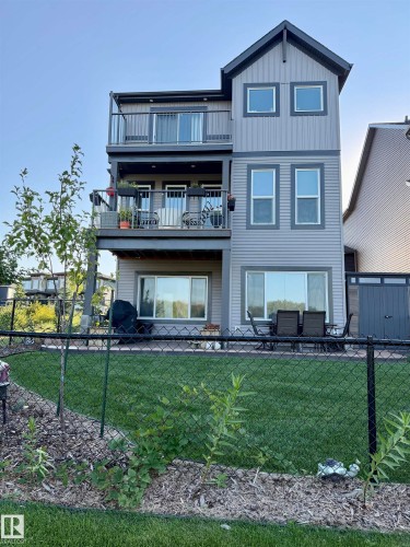 Multi-level rear exterior with dual balconies and ground-level patio - 7135 Edgemont Way Nw, Edmonton, AB 