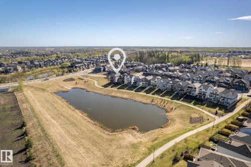 Pond-front property with a walking path, surrounded by residential development and natural areas - 7135 Edgemont Way Nw, Edmonton, AB 
