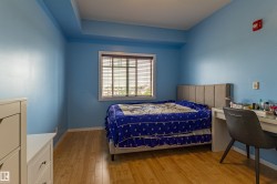 Room featuring wood-finish flooring, a window with horizontal blinds, and a built-in soffit - 