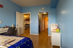 Hardwood-style flooring throughout, featuring a white paneled door with brushed nickel hardware - 