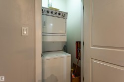 Dedicated laundry alcove featuring a stacked washer and dryer unit - 
