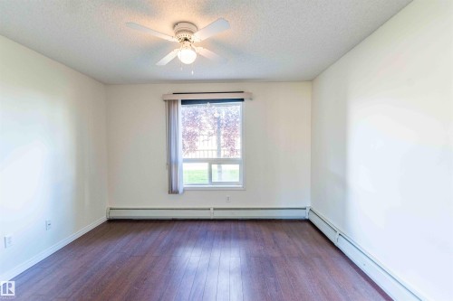 This room features rich wood-look flooring, light-colored walls, and a ceiling fan - #1111 7339 South Terwillegar Dr Nw, Edmonton, AB - Indoor Photo Showing Other Room