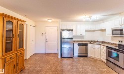 The kitchen features white cabinetry, stainless steel appliances, and a tiled floor - 
