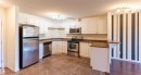 The kitchen features white cabinetry, stainless steel appliances, and brown tiled flooring - #1111 7339 South Terwillegar Dr Nw, Edmonton, AB  - Indoor Photo Showing Kitchen With Stainless Steel Kitchen 