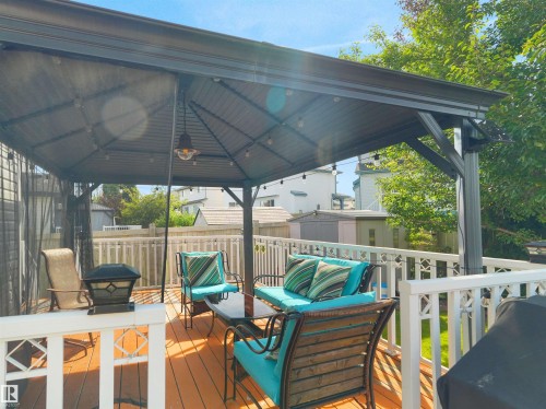 Spacious outdoor deck with a permanent gazebo structure, string lighting, and white perimeter railing - 614 Silver Berry Road Nw, Edmonton, AB - Outdoor With Deck Patio Veranda