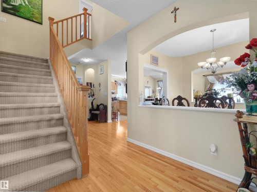 Hardwood flooring, carpeted staircase, wood banister, archway, and recessed lighting - 614 Silver Berry Road Nw, Edmonton, AB - Indoor Photo Showing Other Room