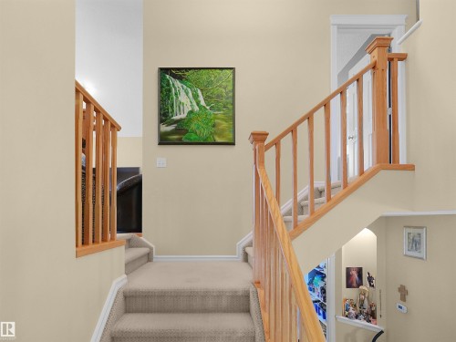 Multi-level staircase featuring light wood railings and neutral carpeted treads - 614 Silver Berry Road Nw, Edmonton, AB - Indoor Photo Showing Other Room