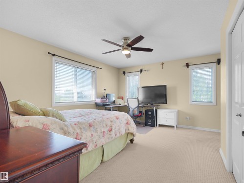 Recessed lighting, ceiling fan with integrated lighting, multiple windows with blinds, carpeted flooring, and a white interior door - 614 Silver Berry Road Nw, Edmonton, AB - Indoor Photo Showing Bedroom