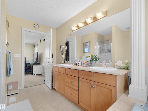 Dual sink vanity with light wood cabinetry, a large mirror, and overhead lighting - 614 Silver Berry Road Nw, Edmonton, AB - Indoor Photo Showing Bathroom