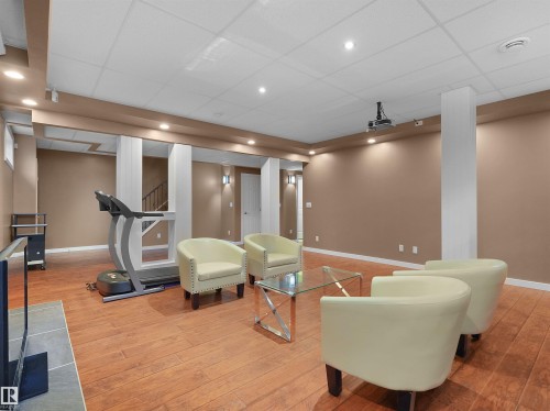 Recessed lighting, wood-finish flooring, drop ceiling, architectural columns, and wall sconces - 614 Silver Berry Road Nw, Edmonton, AB - Indoor Photo Showing Gym Room