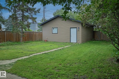 Detached garage featuring horizontal siding, a single window, and a separate entry door - 11739 129 Street Nw, Edmonton, AB 
