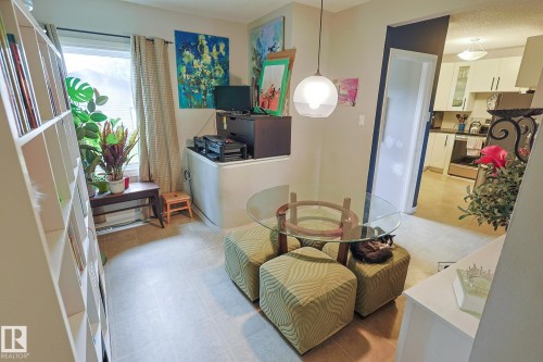 Built-in shelving, window with natural light, tiled flooring, glass-top table, and a contemporary pendant light fixture - 11739 129 Street Nw, Edmonton, AB 