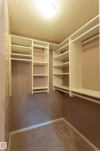 Custom closet organization system featuring shelving and hanging rods - #204 2420 108 St Nw, Edmonton, AB - Indoor With Storage