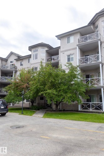 Multi-story building with multiple balconies featuring white decorative railings - #204 2420 108 St Nw, Edmonton, AB - Outdoor