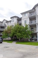 Multi-story building with multiple balconies featuring white decorative railings - 