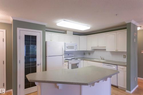 White kitchen cabinets with an integrated oven and microwave - #204 2420 108 St Nw, Edmonton, AB - Indoor Photo Showing Kitchen