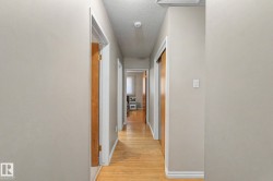 Wood-finish flooring extending throughout, neutral wall paint, and white trim accents - 