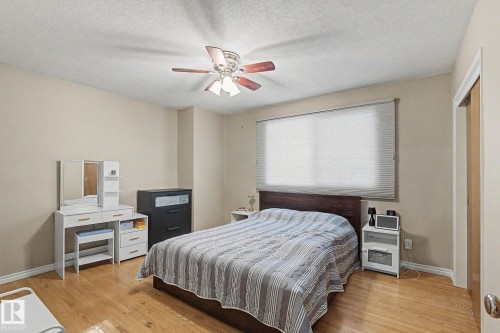 Wood-finish flooring, ceiling fan, window with privacy blinds, and light-toned walls - 4323 114B Street Nw, Edmonton, AB - Indoor Photo Showing Bedroom