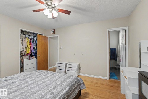 Wood-finish flooring with a ceiling fan light fixture - 4323 114B Street Nw, Edmonton, AB - Indoor Photo Showing Bedroom