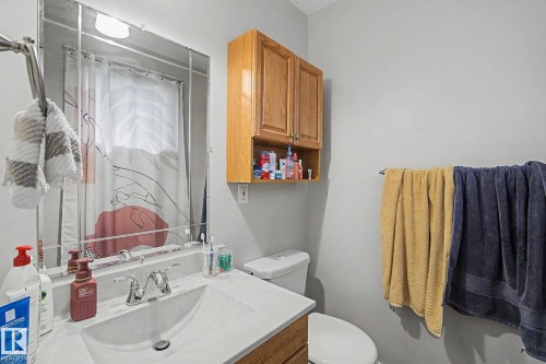 Vanity with integrated sink, chrome faucet, and framed wall mirror - 4323 114B Street Nw, Edmonton, AB - Indoor Photo Showing Bathroom