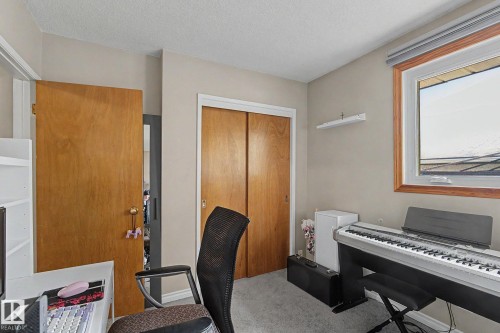 Recessed window with wood-finish trim, light grey wall paint, and grey carpet flooring - 4323 114B Street Nw, Edmonton, AB - Indoor Photo Showing Office