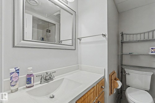 Bathroom featuring a vanity with a white countertop, chrome fixtures, and a framed mirror - 4323 114B Street Nw, Edmonton, AB - Indoor